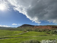 a view of a grassy field with a cloudy sky