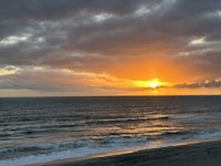 the sun is setting over the ocean